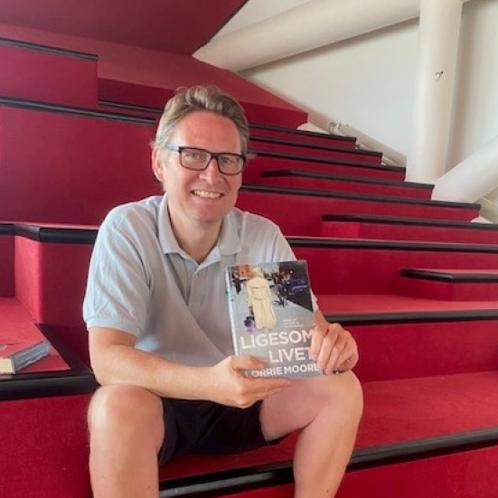 Bibliotekar Bjørn Berger holder bog frem på Biblioteket Kulturværftet