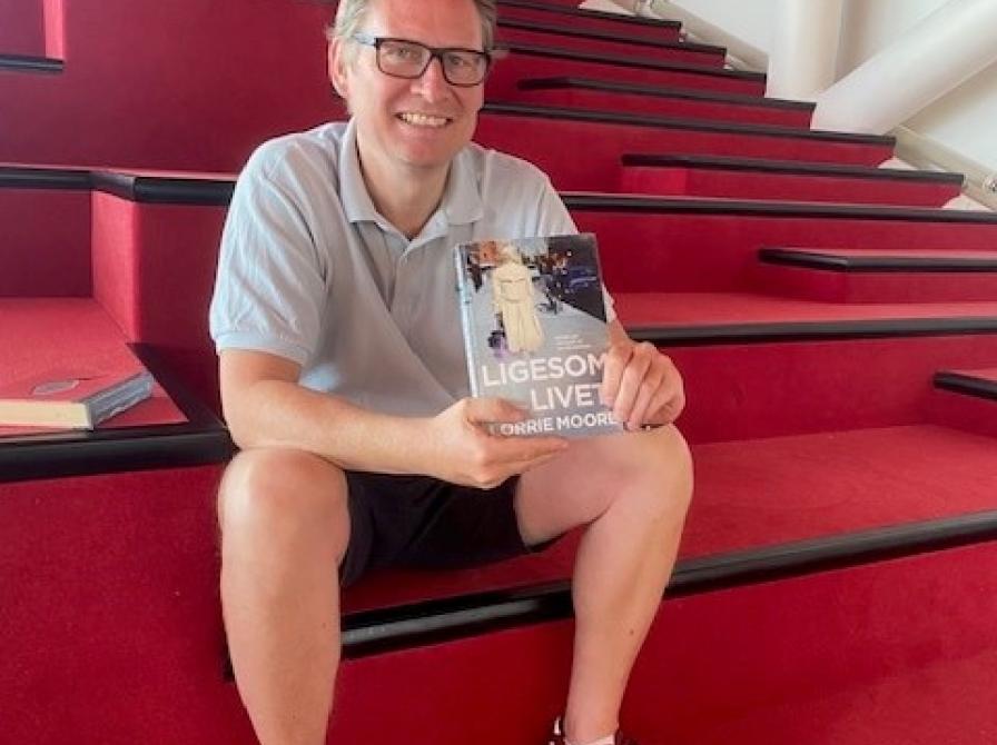 Bibliotekar Bjørn Berger holder bog frem på Biblioteket Kulturværftet