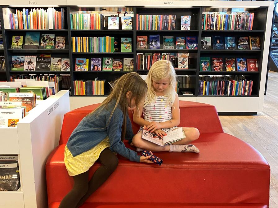 Børn der læser på biblioteket