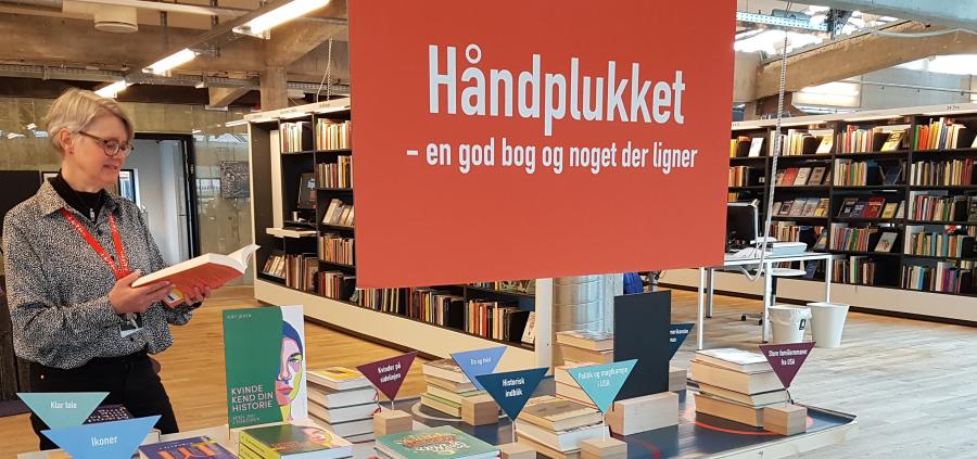 Foto af bibliotekar Hanne Pedersen ved Håndplukket-bordet