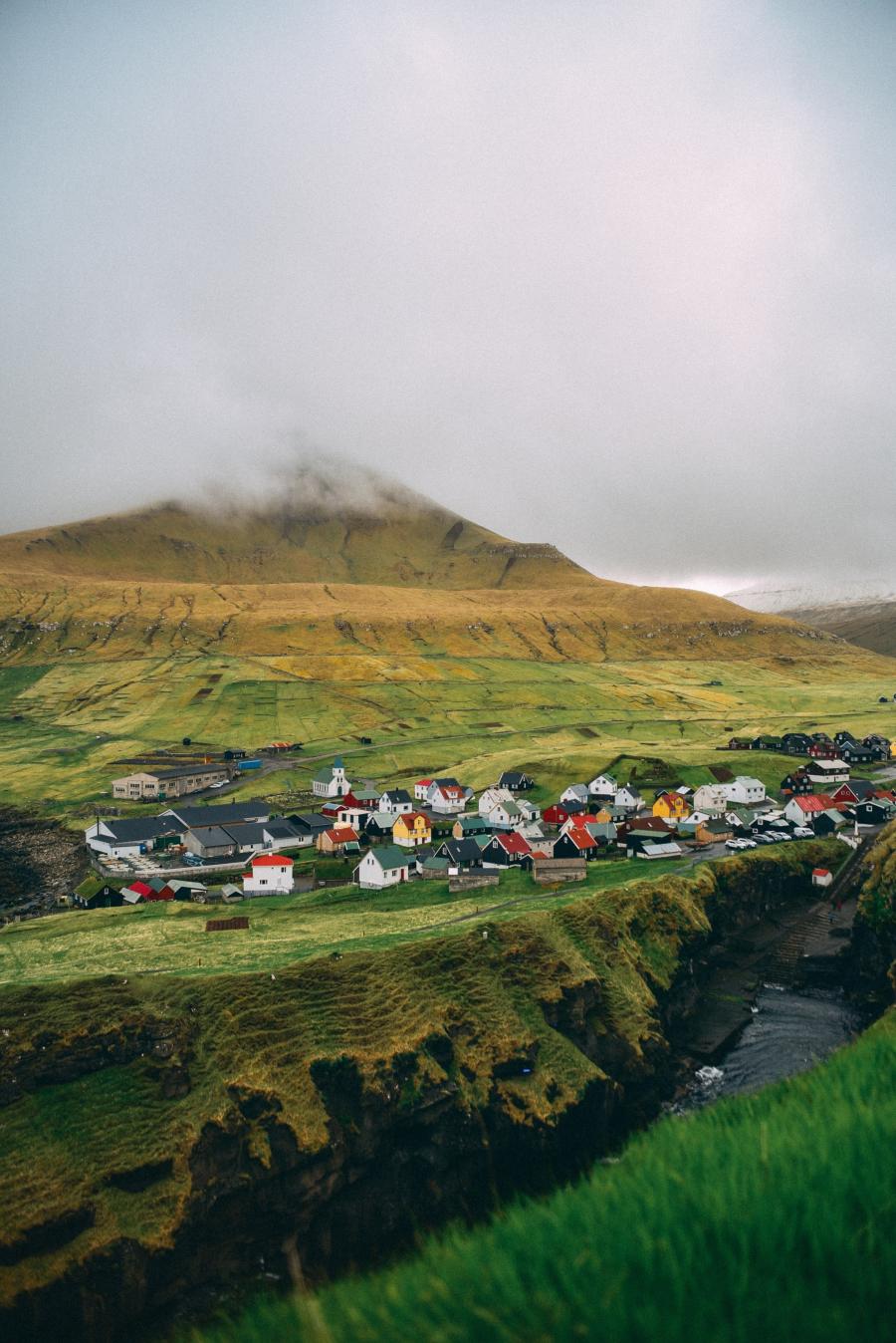 Små, farvede huse op ad en fjeldside i en færøsk bygd
