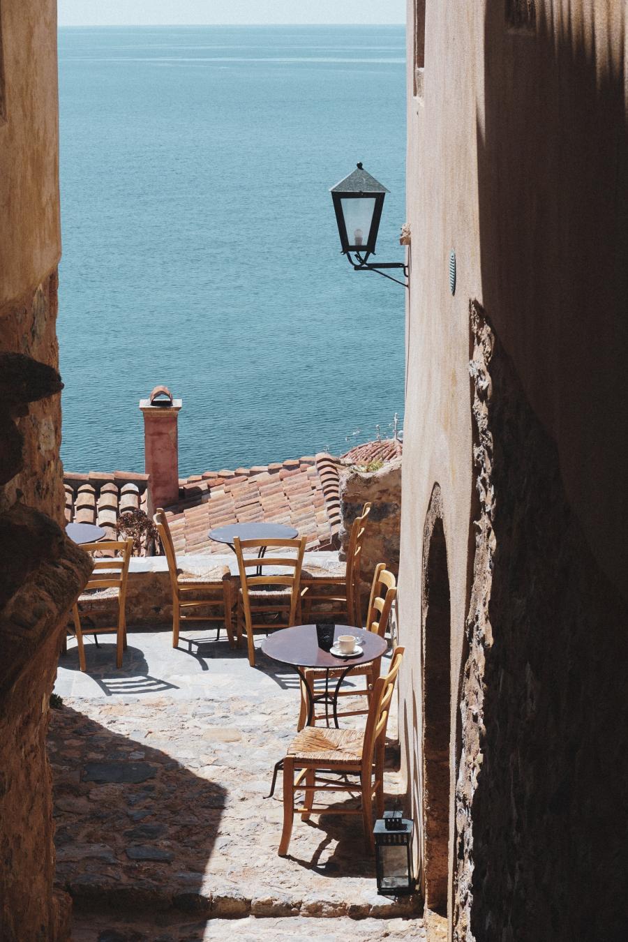 Udstigt over caféborde, tegltage og Middelhavet