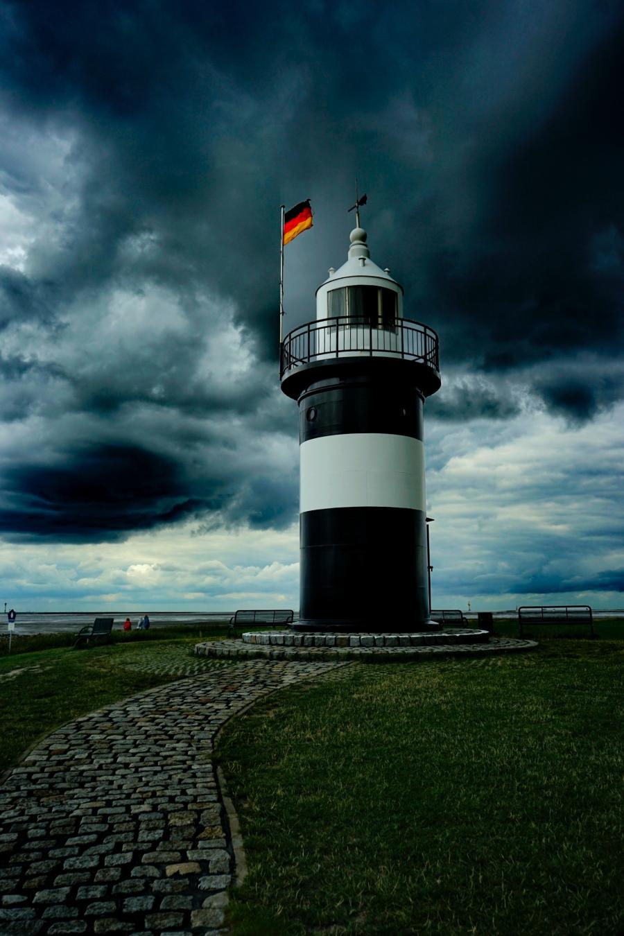 Tysk flager vejer over fyrtårn. Mørk himmel i baggrunden